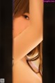 A close up of a woman's face peeking out from behind a curtain.