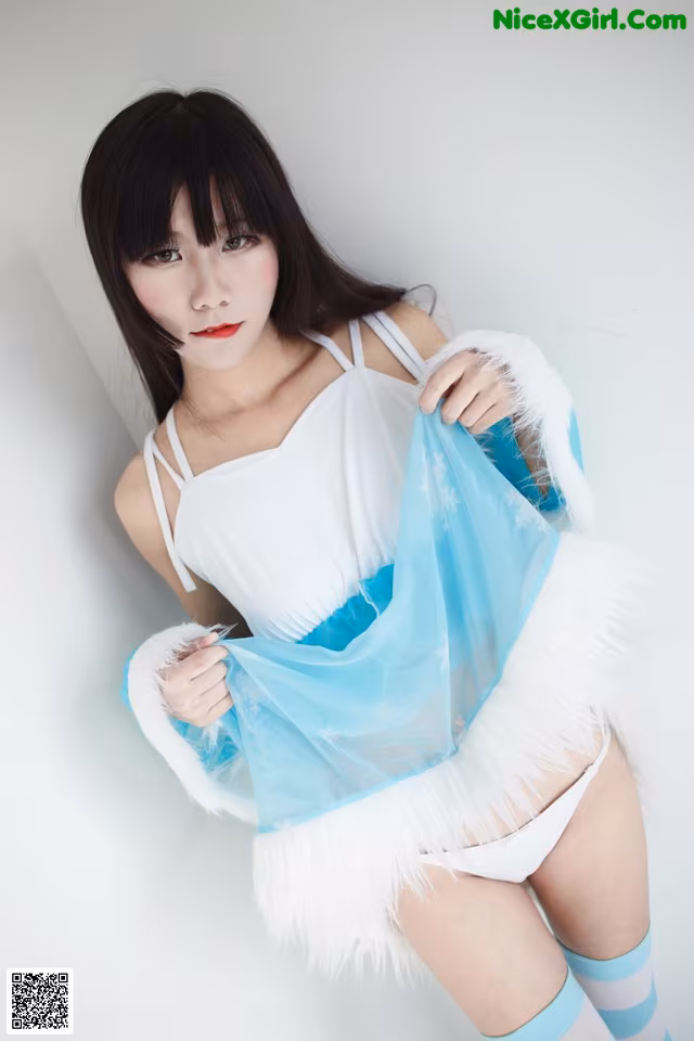 A woman in a white and blue outfit posing for a picture.