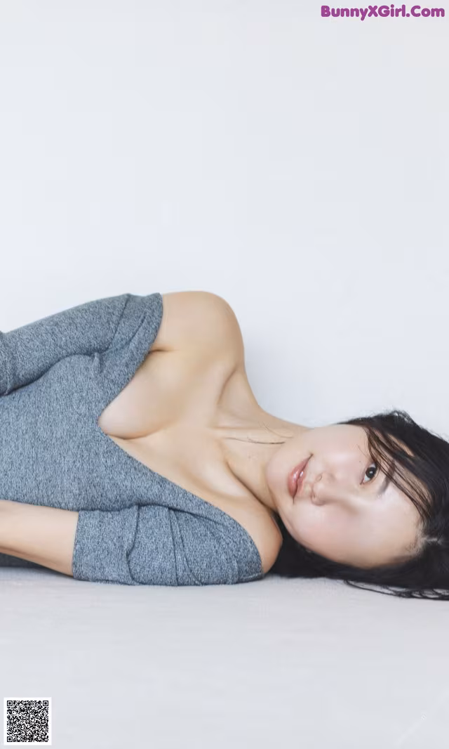 A woman laying on the ground with her legs crossed.