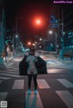 A woman in a cat mask is standing in the middle of the street.