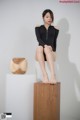 A woman sitting on top of a wooden box.