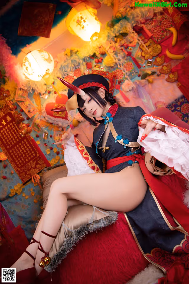 A woman in a red and black outfit sitting on a red couch.