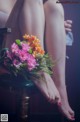 A woman sitting on a chair holding a bouquet of flowers.