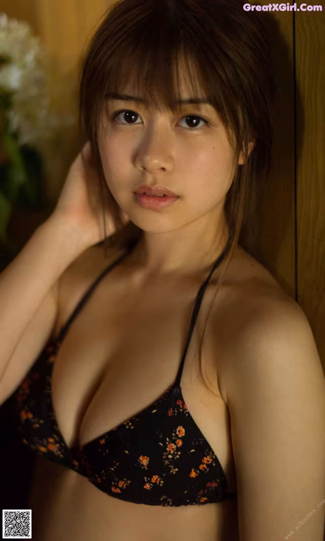 A woman in a black bikini posing for a picture.