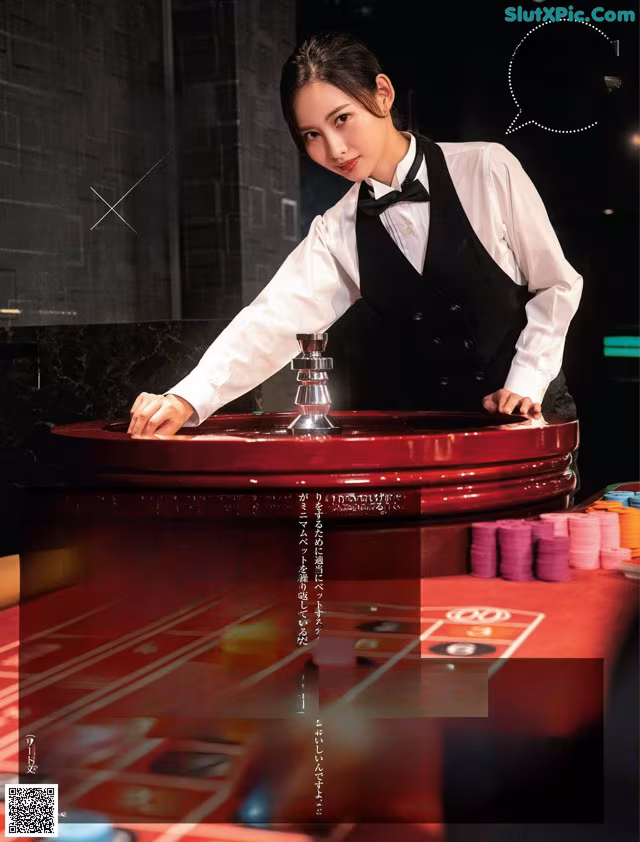 A woman in a tuxedo playing roulette at a casino table.