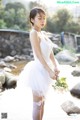 A woman in a white dress holding a bouquet of flowers.