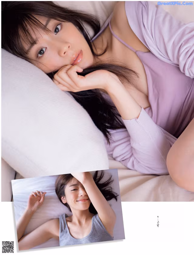 A woman laying on top of a bed next to a pillow.