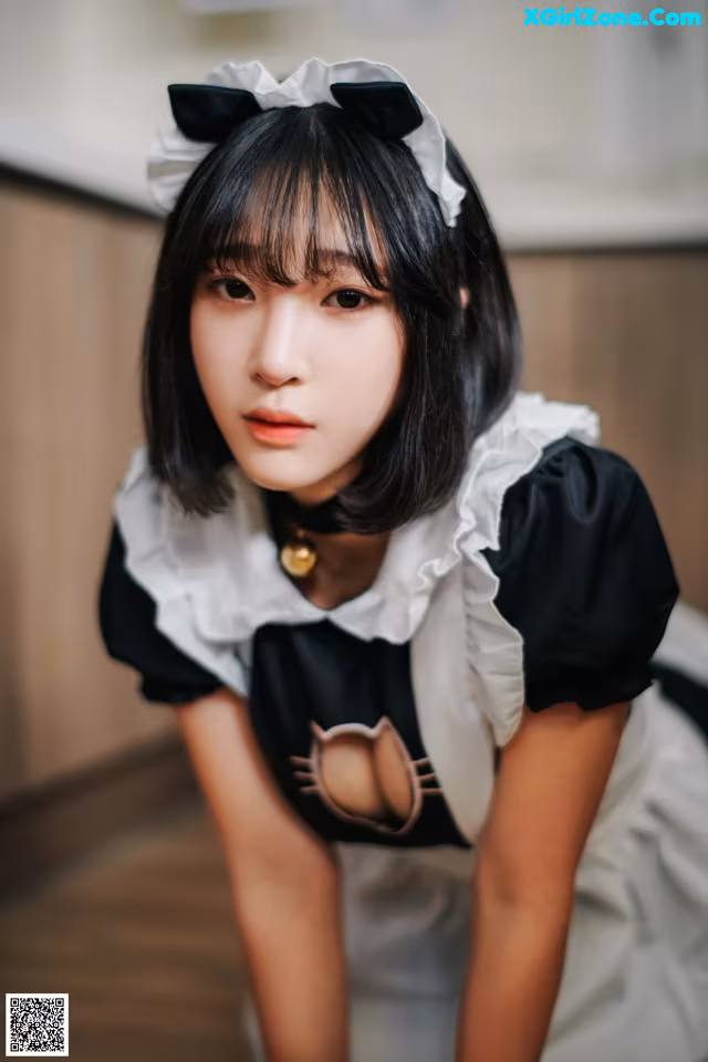 A woman in a maid outfit posing for a picture.