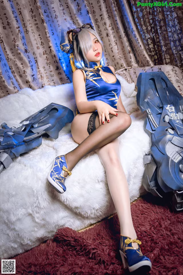 A woman sitting on top of a bed next to a pair of shoes.