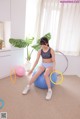 A woman sitting on an exercise ball with a hula hoop.