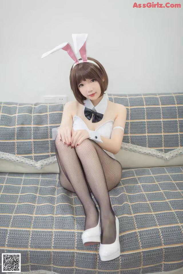 A woman in a bunny costume sitting on a couch.